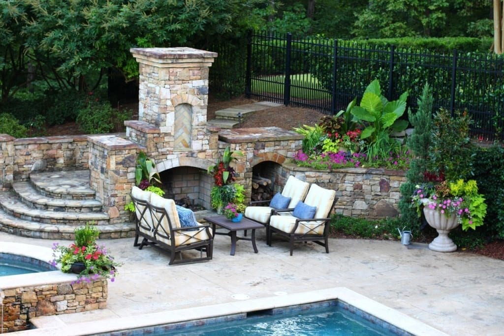 Yellow stripe outdoor furniture cushions. Outdoor furniture by stone fireplace.