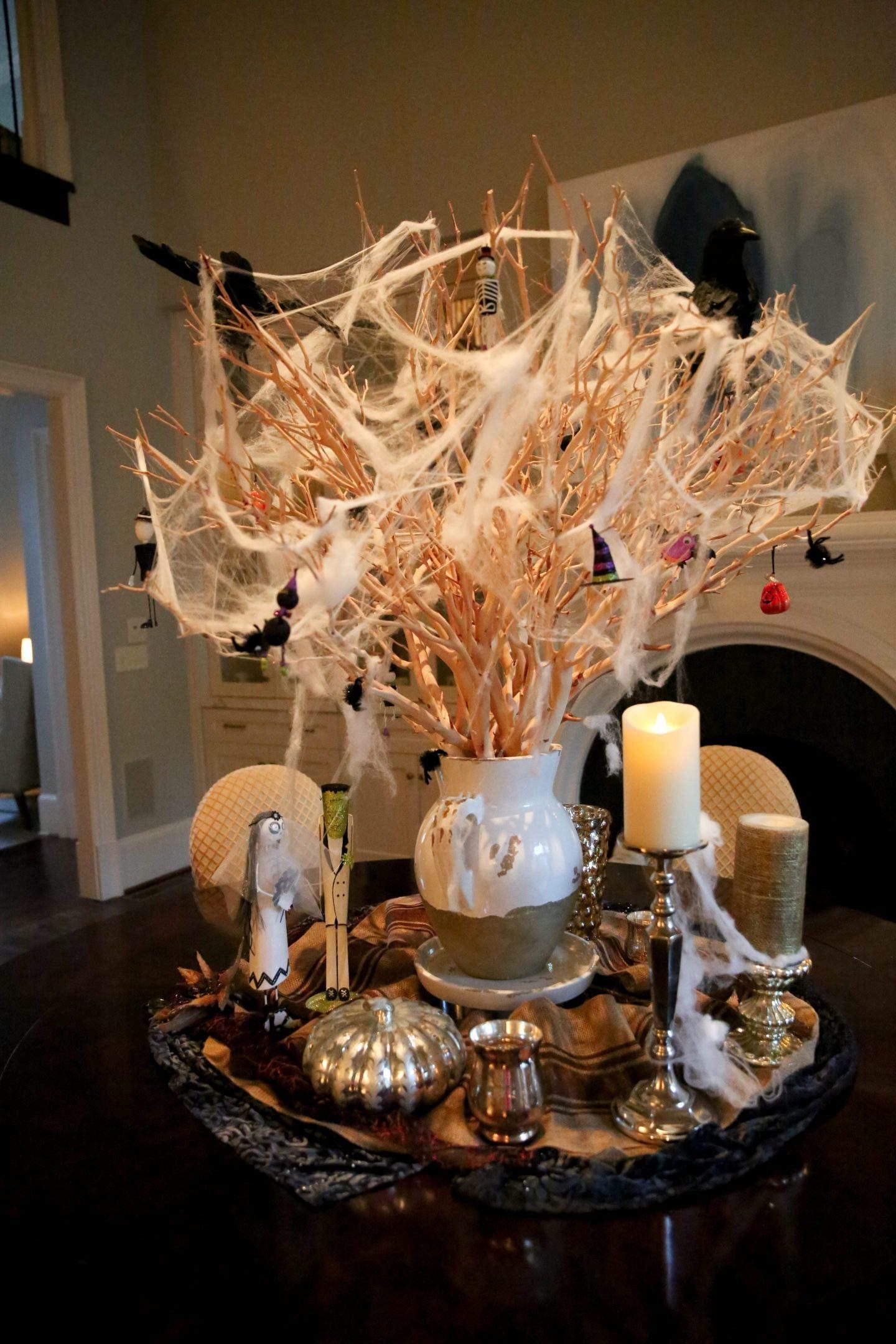 Halloween centerpiece. Decorating manzanita branch centerpiece with black crows and spider webs and Halloween ornaments from Pier 1.