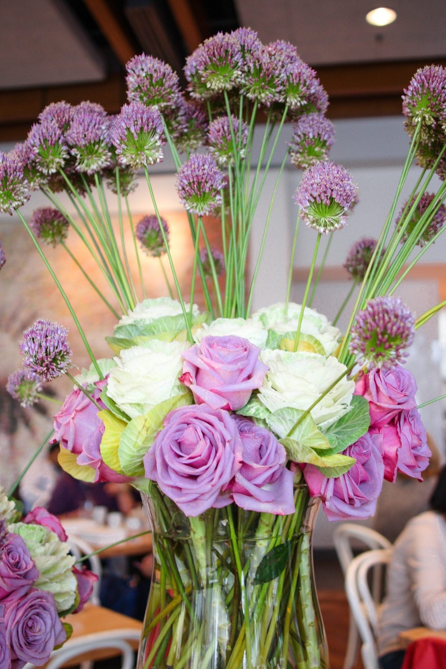 flower arrangement with purple thistles and purple and white roses