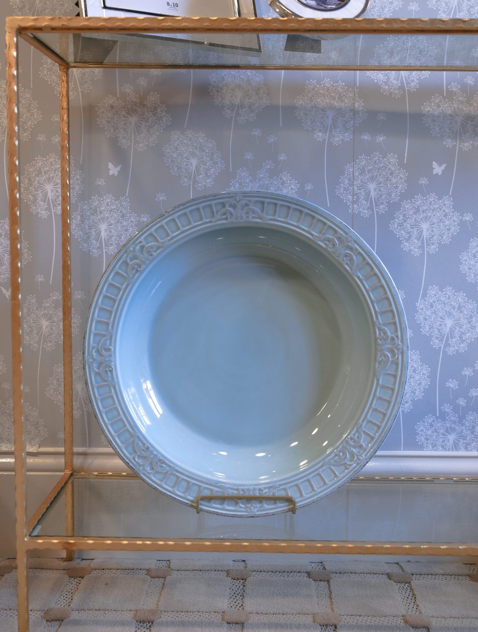 Decorative blue plate and gold console table.