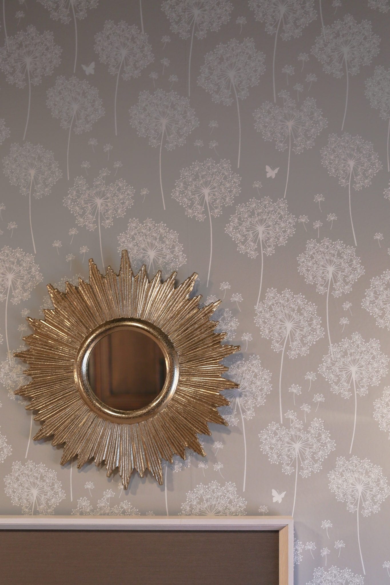 Starburst gold mirror with gray reusable wallpaper.