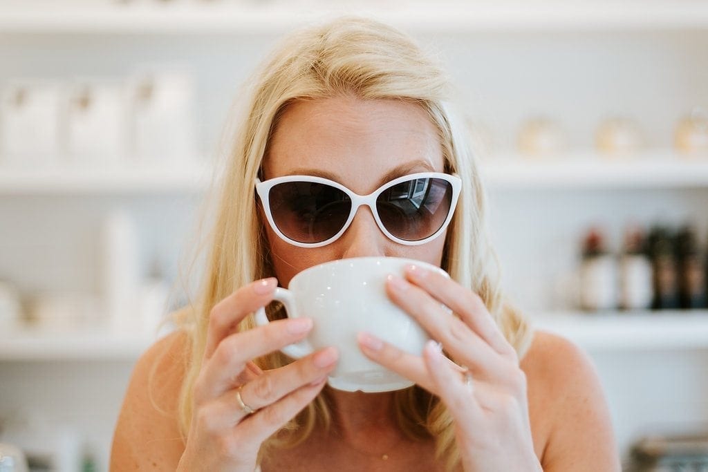 Atlanta blogger in white cat eye sunglasses drinking coffee ranting. I hate fast fashion and the fast fashion industry. Fast fashion facts and rants from a woman trying to just buy clothes that will last.