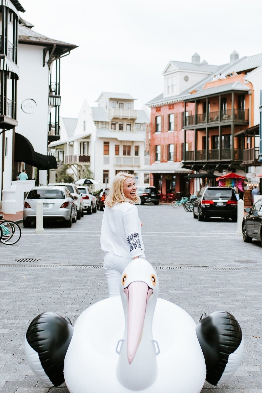 Atlanta Lifestyle Blogger Kelly Page dragging Sir Pelican the giant raft down streets of Rosemary Beach.