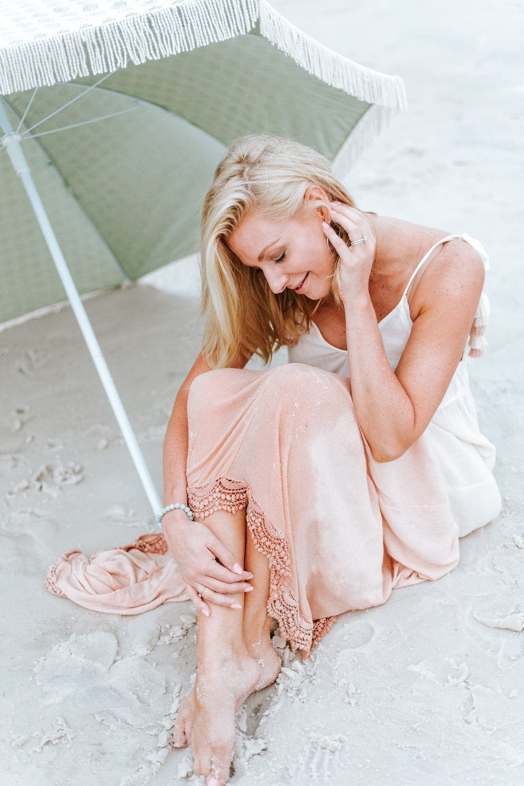 Nude Pink beach dress. Sand in your toe, wind in your hair - and lace and tassels. This is a beautiful dress to wear on vacation. Look right at home at sunset walking to dinner with the beach breeze. This fringe umbrella is in sea glass green.