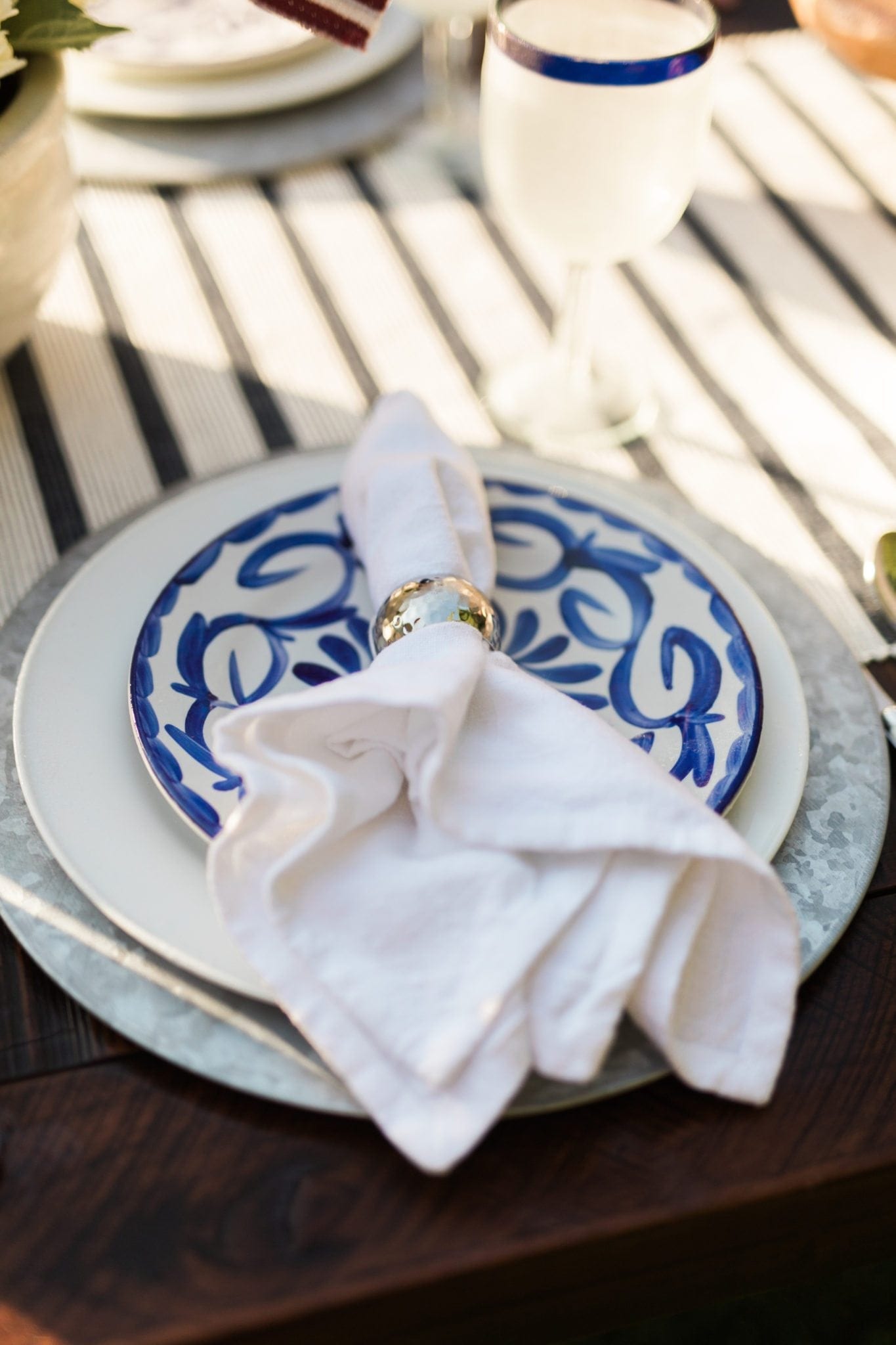 Blue and white dishware. White linen napkin and silver napkin ring.