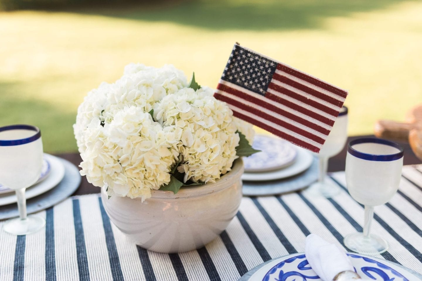Patriotic decorations. July 4th centerpiece with white hydrangeas and American flag flower display.