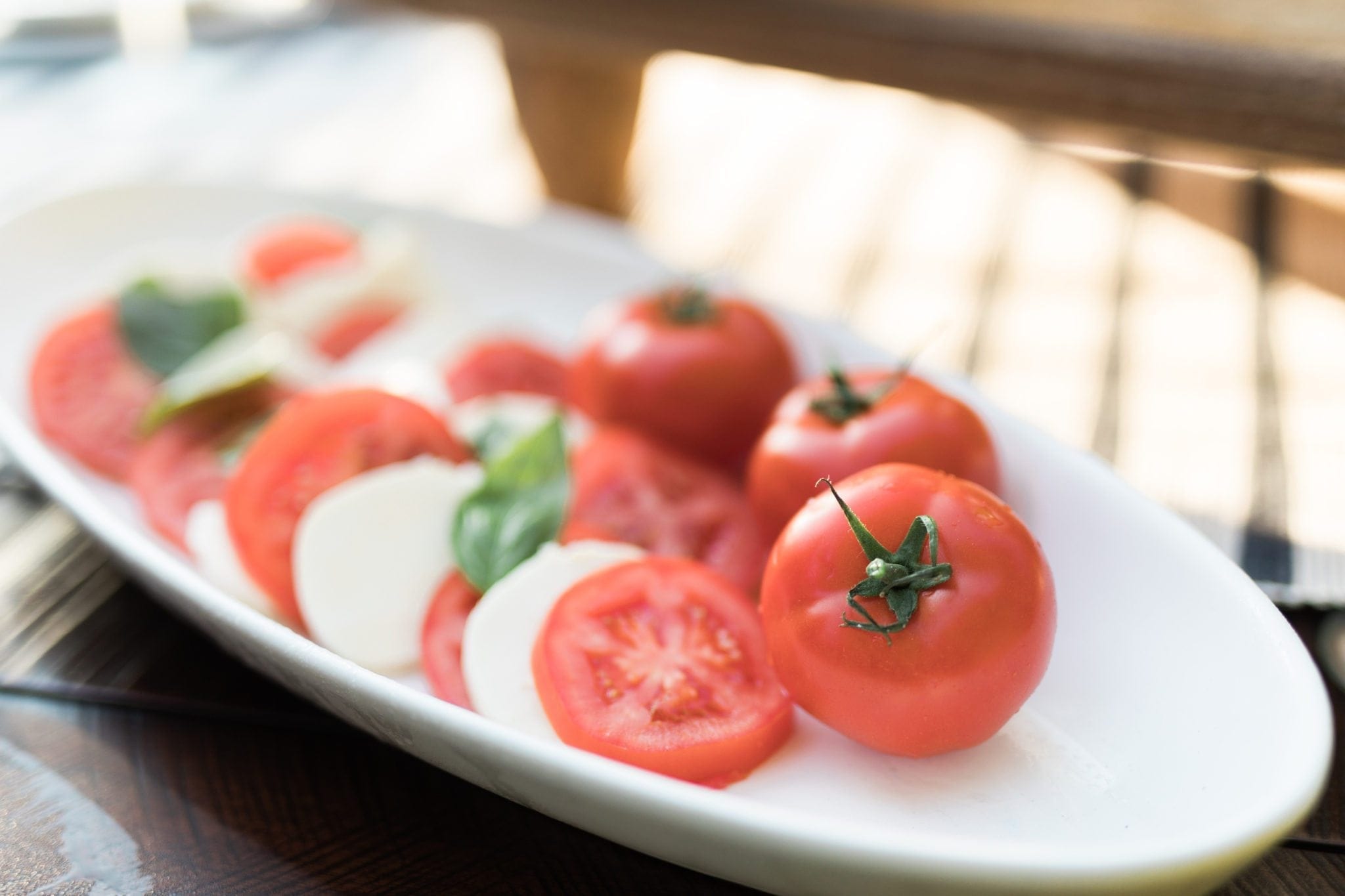 Caprese salad on white platter.