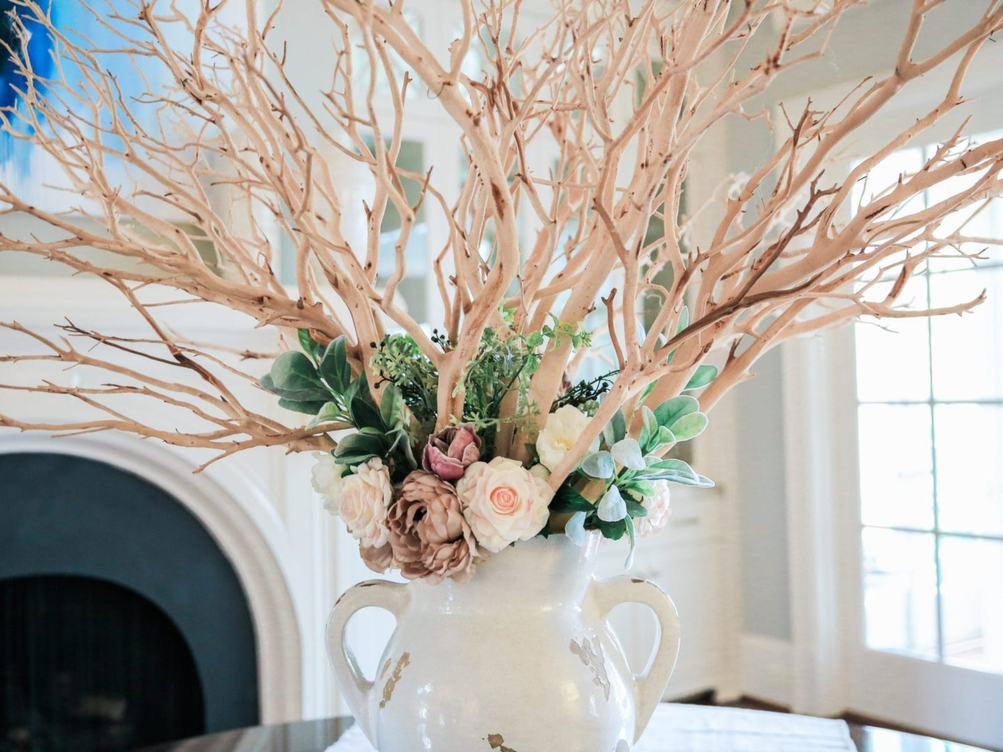 fake flowers that look real in vase using manzanita stick branches and roses.
