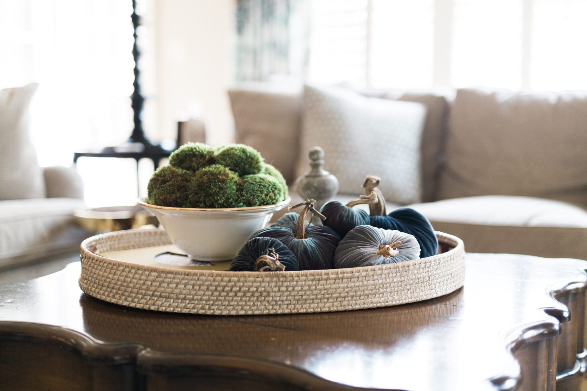 Plush Pumpkin on a rattan tray on a family room coffee table.