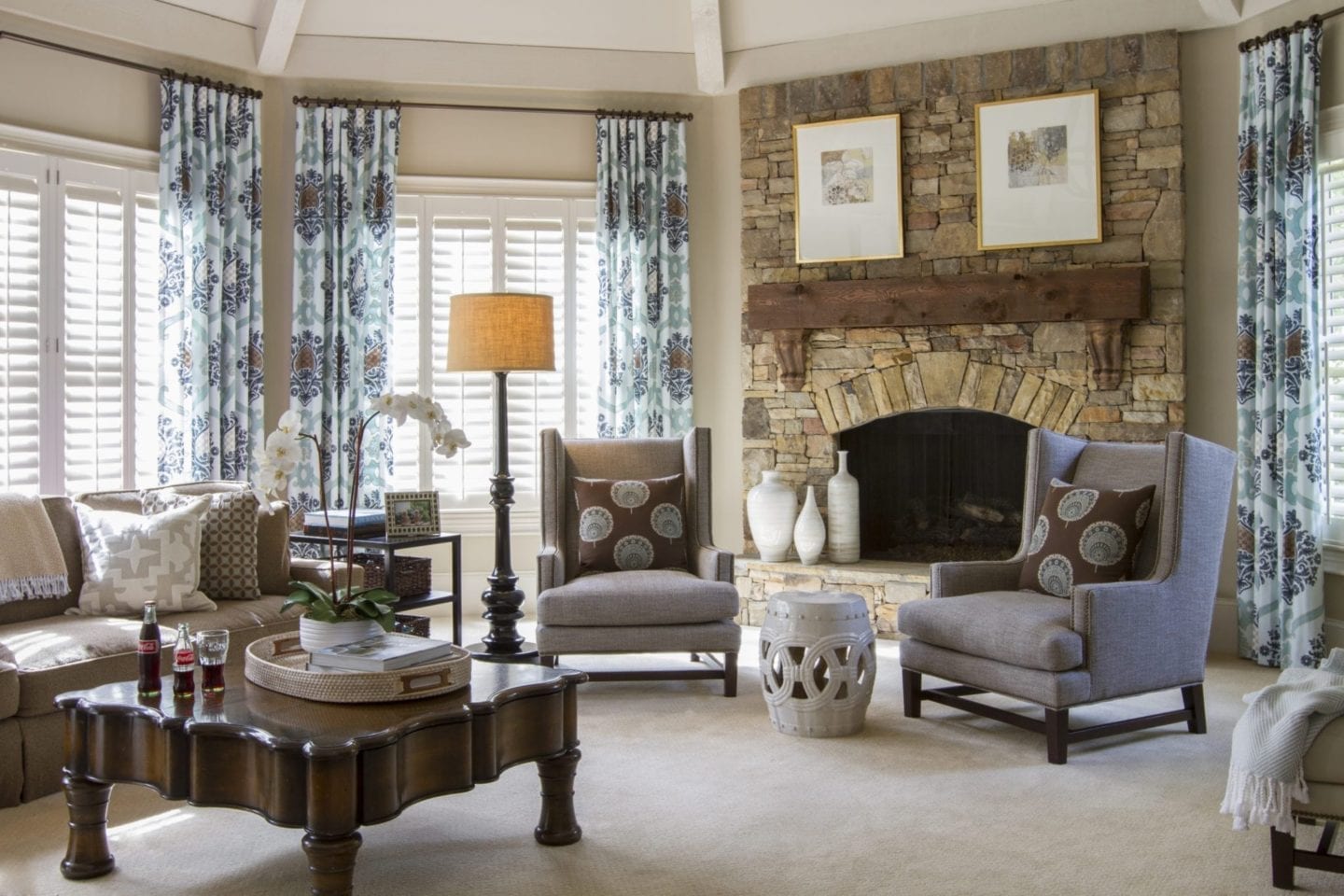 Traditional family room with stone and wood fireplace and blue drapery.
