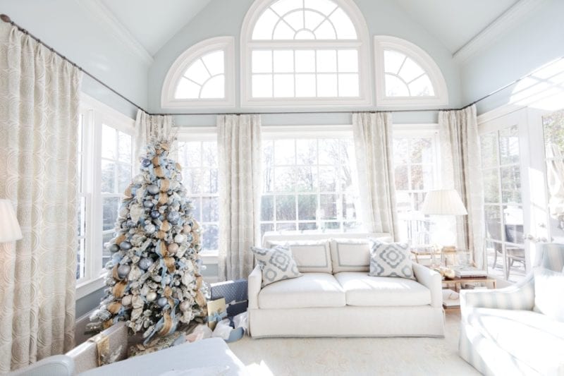 Light blue paint colors for your home. Sunroom filled with light. Large windows in blue and neutral decorated room.