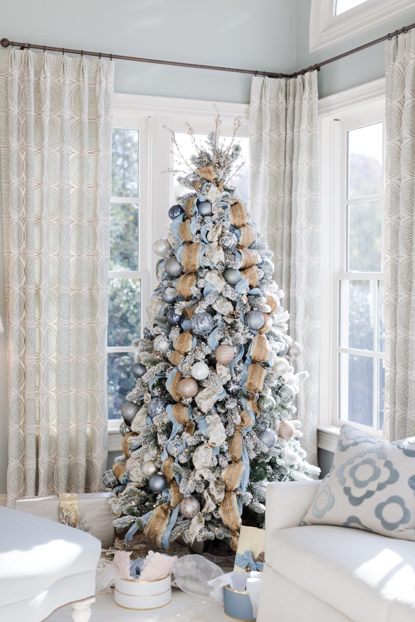 Gold ribbon and blue ribbon on blue and gold Christmas tree with gold and silver ornaments. This baby blue Christmas tree is a Cinderella inspired tree.
