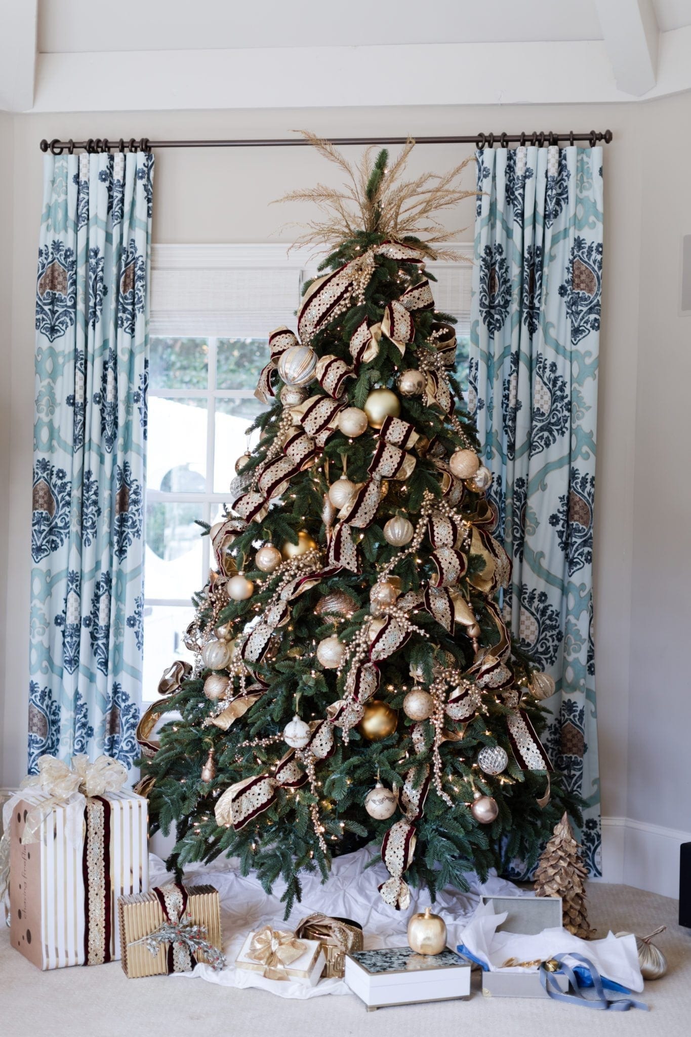 Frontgate holiday ribbon with gold glitter ribbon. Traditional Christmas tree and blue drapery.