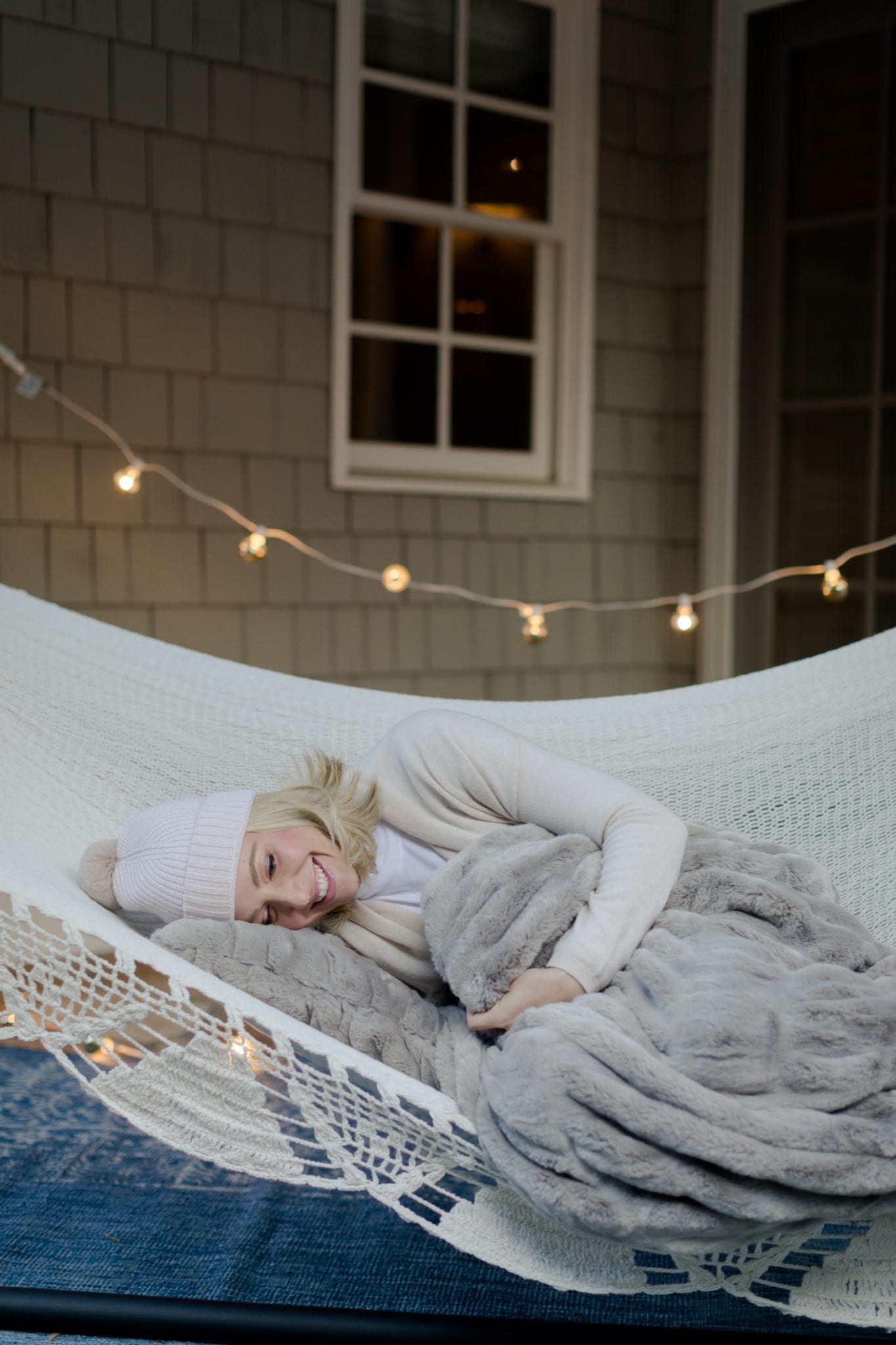 Fall home decor for outdoors. Outdoor hammock with soft pink beanie hat and cozy blanket.