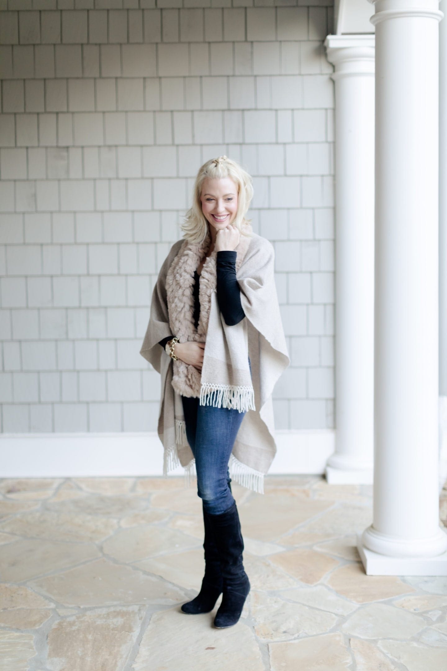 Knee High suede black boots with heel and tan cape and scarf. Short blonde hairstyle. 