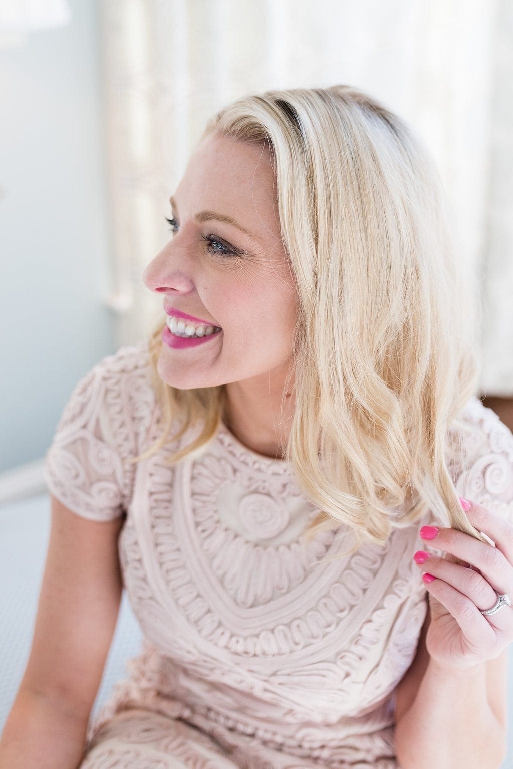 Bob hairstyle with pink nail polish. Light pink dress with sleeve.