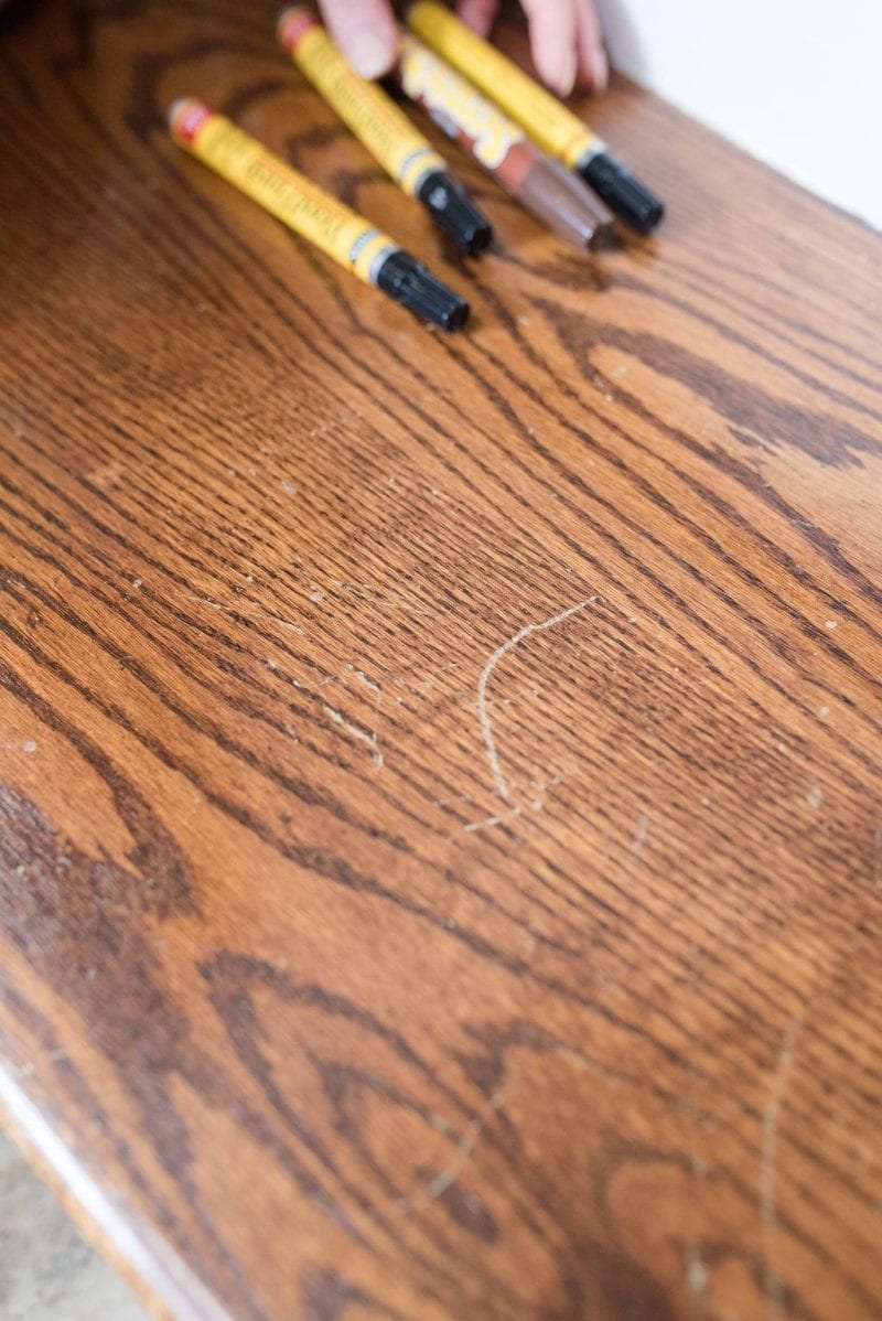 Fixing scratches on wood floors using wood repair markers. 