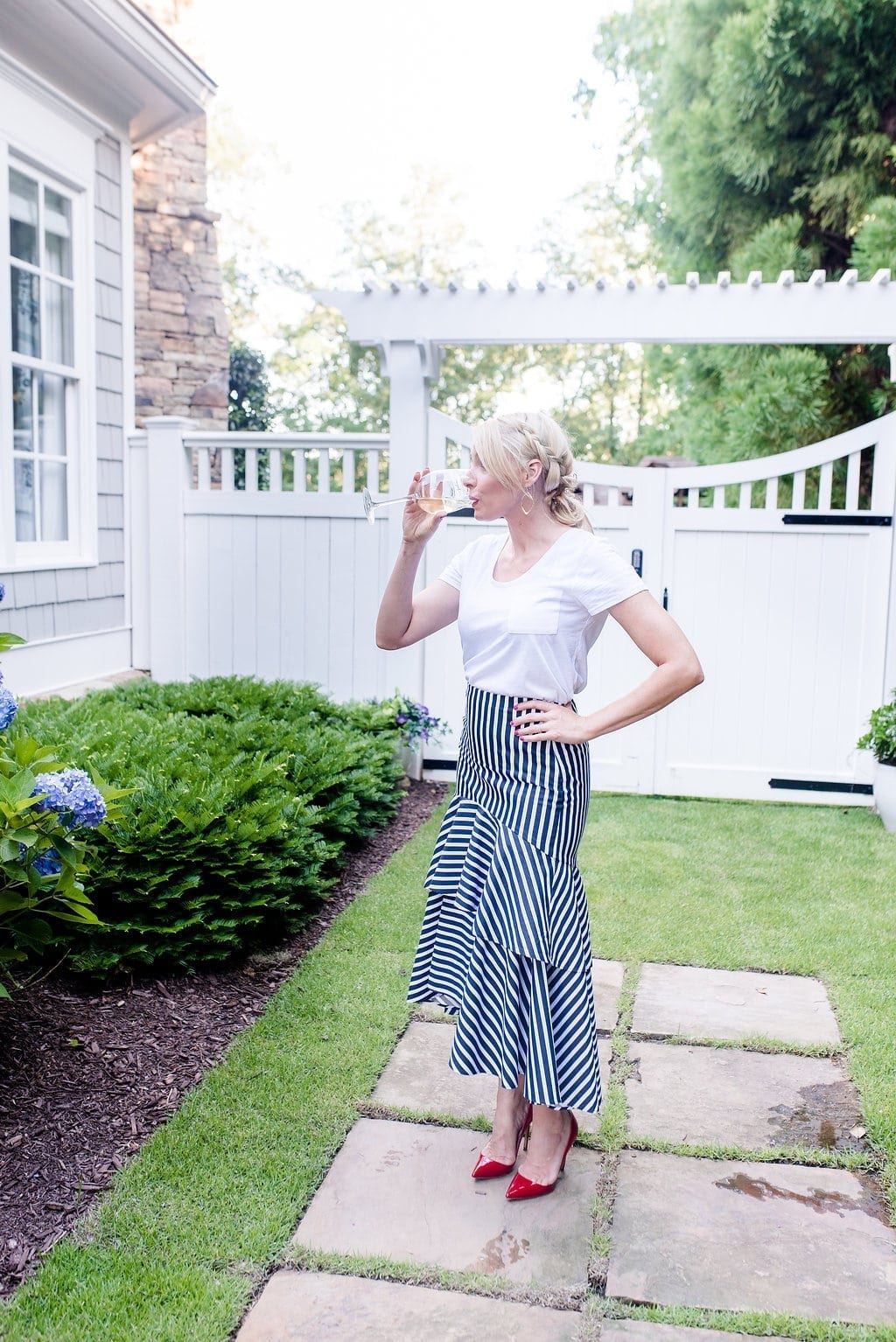 4th of July outfit. White t shirt with ruffle midi length skirt and red shoes.
