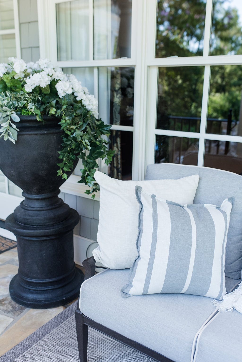 Large outdoor planters in black. Gray cedar home with patio furniture in aluminum.