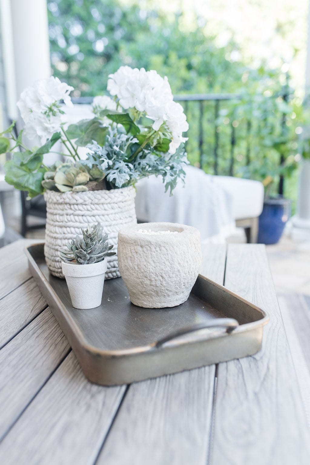 Accessorizing outdoor spaces. Gray aluminum tray with gold, faux succulents and faux flowers.