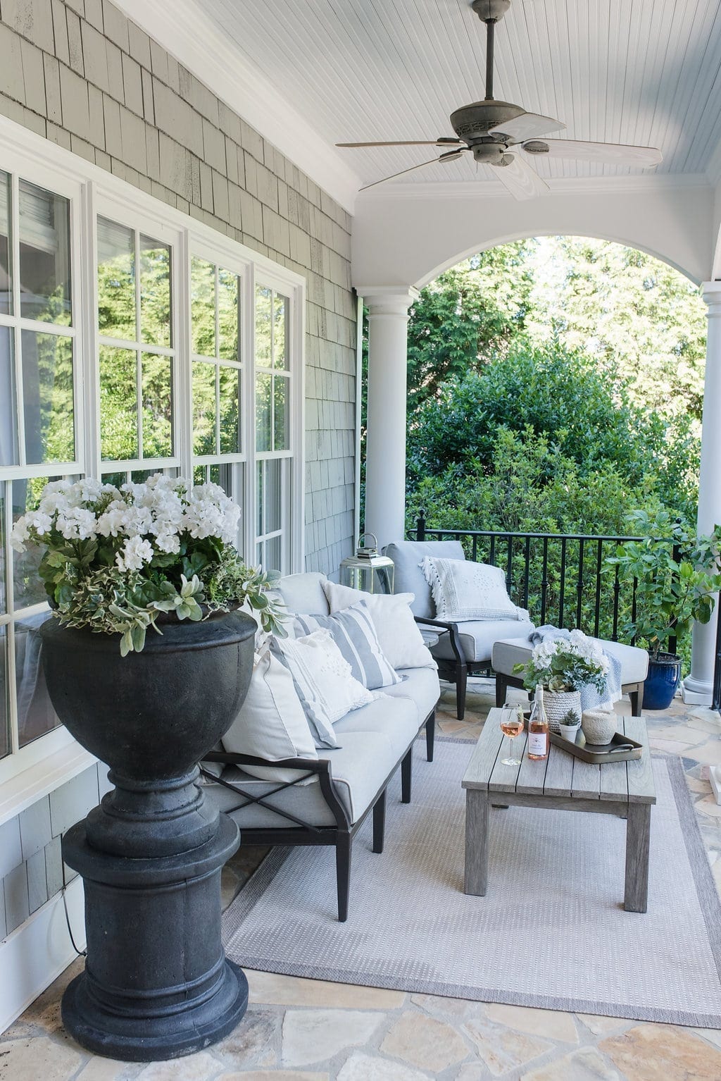 Gray and white outdoor furniture. Teak table and cushioned outdoor furniture.