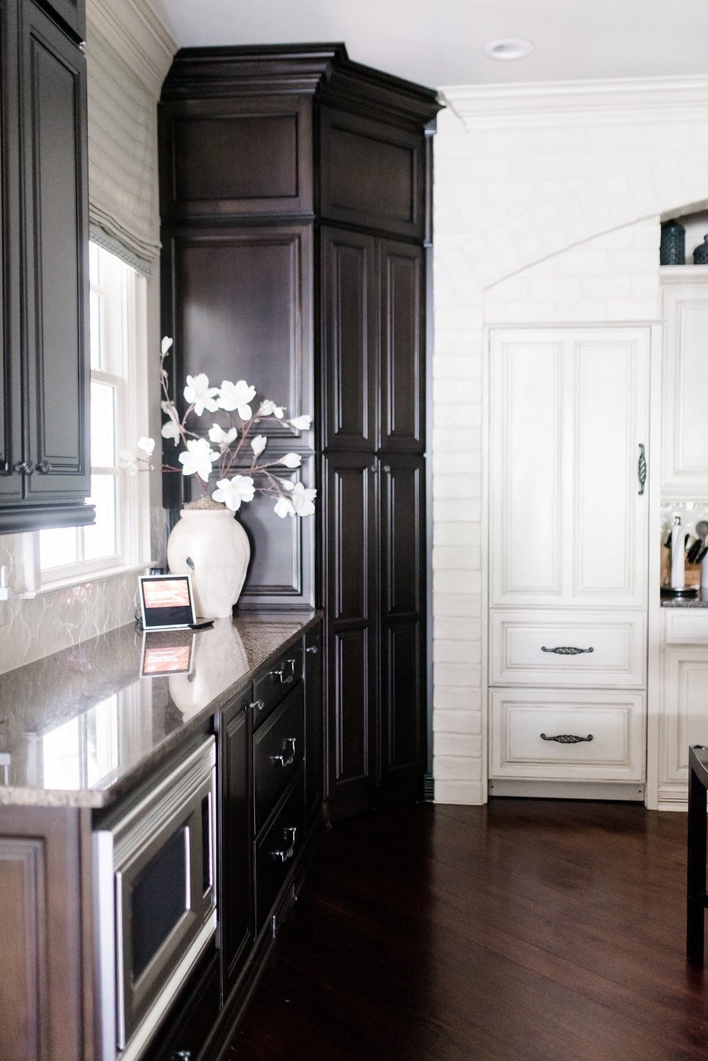 Amazon Alexa Show in kitchen. White painted brick with espresso stained cabinetry. 