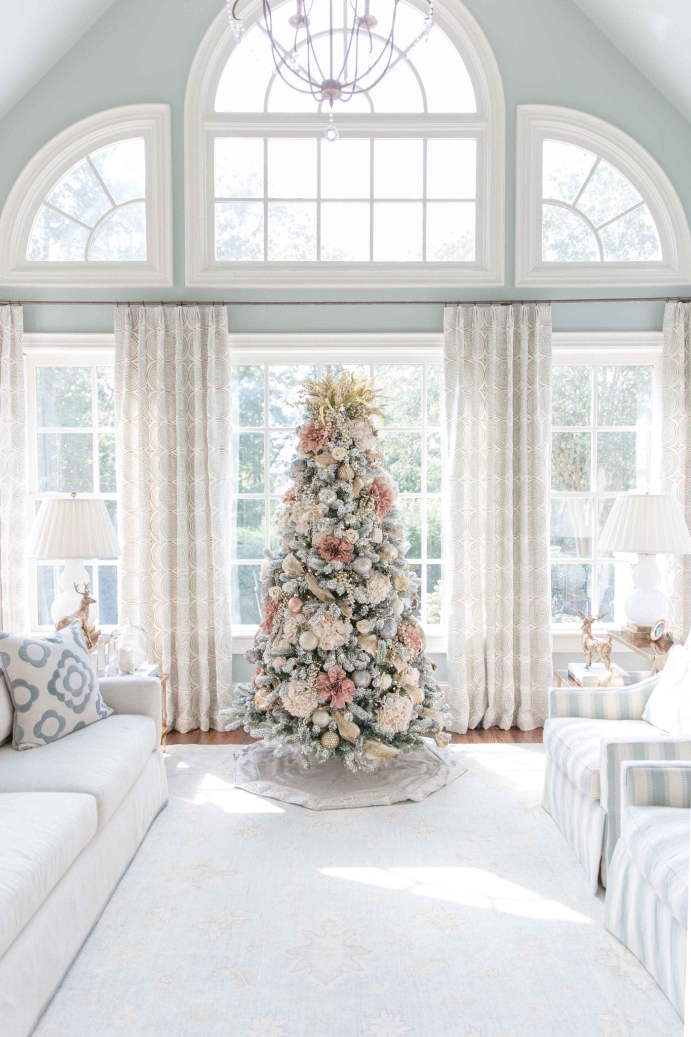 Soft pink Christmas Tree in light blue family room. Create a beautiful flocked tree with pink flowers and cream flowers and a hint of gold! 