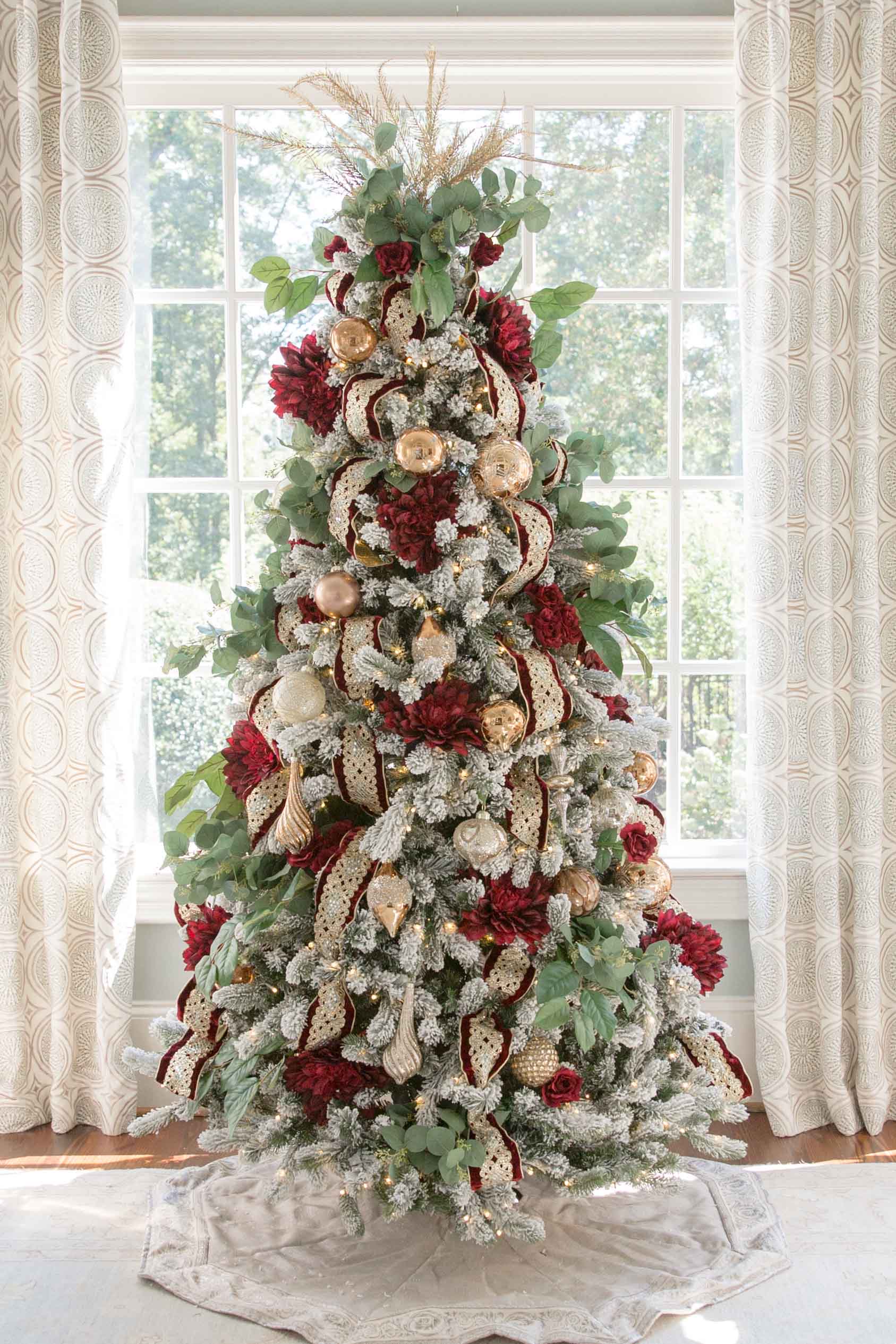 Red and Gold Christmas Tree. Intricate and ornate gold wired ribbon, dark red dahlias and deep red roses decorate this flocked tree in traditional colors. See two ways to decorate a flocked Christmas tree. More how to design a traditional tree posts coming soon!