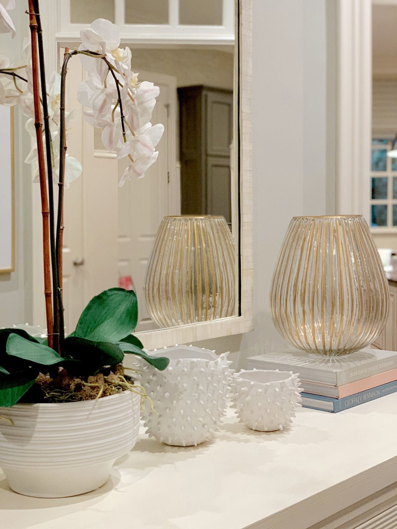 Coffee Table Decorations with White Urchin Vases, Gold vase and fake orchid plant.