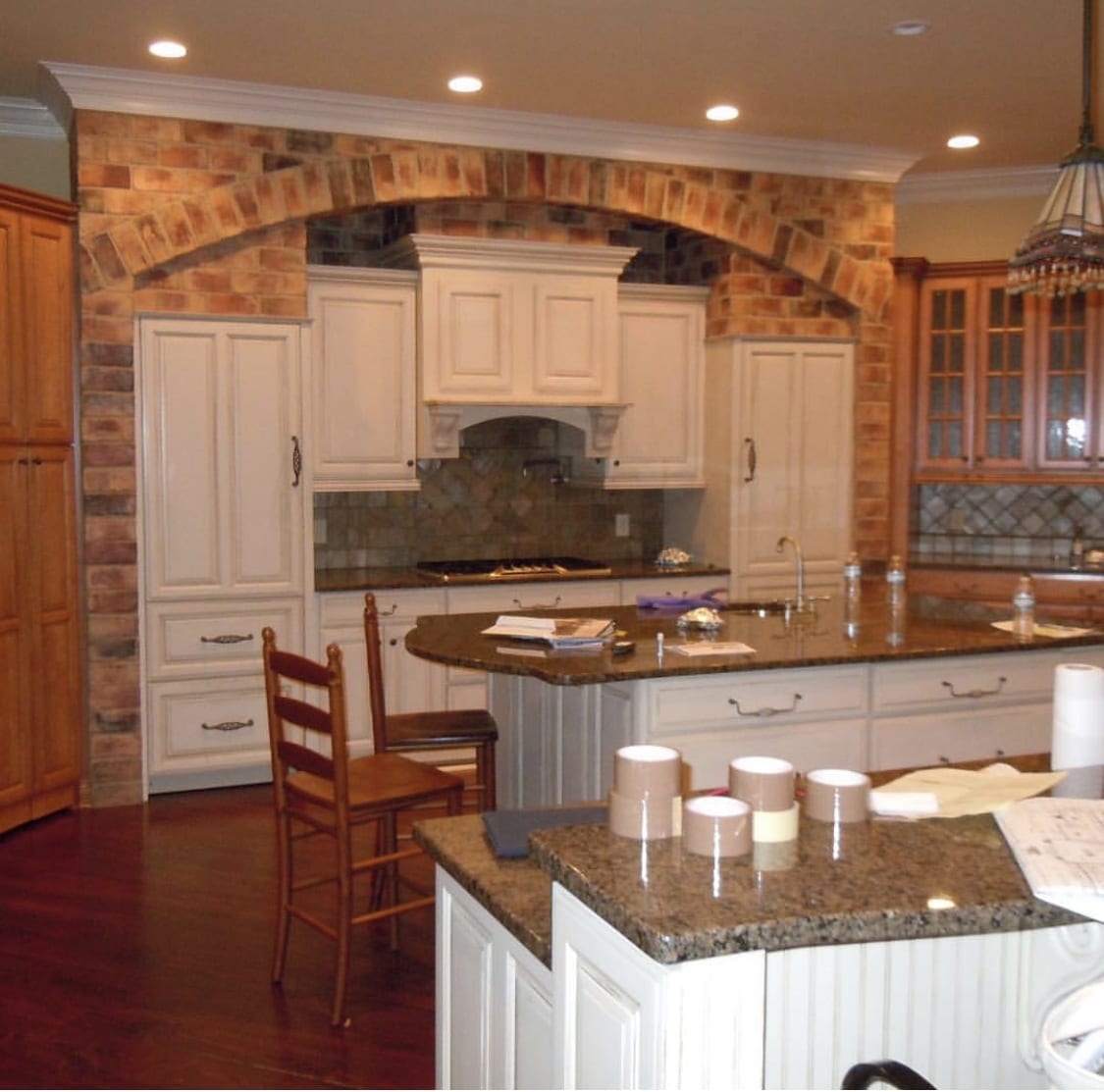 Kitchen with faux brick and white cabinetry,