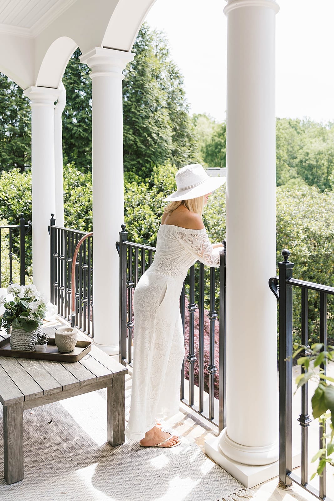 Vacation Outfit for Italy. White lace jumpsuit with white summer hat on lifestyle blogger, Kelly Page, for BlueGrayGal.