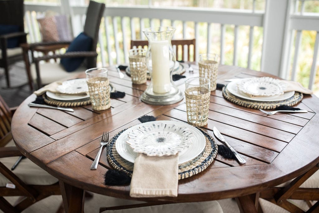 Outdoor table setting ideas. Make a rustic wood table pop with glamorous plates from Anthropologie home and rattan chargers.