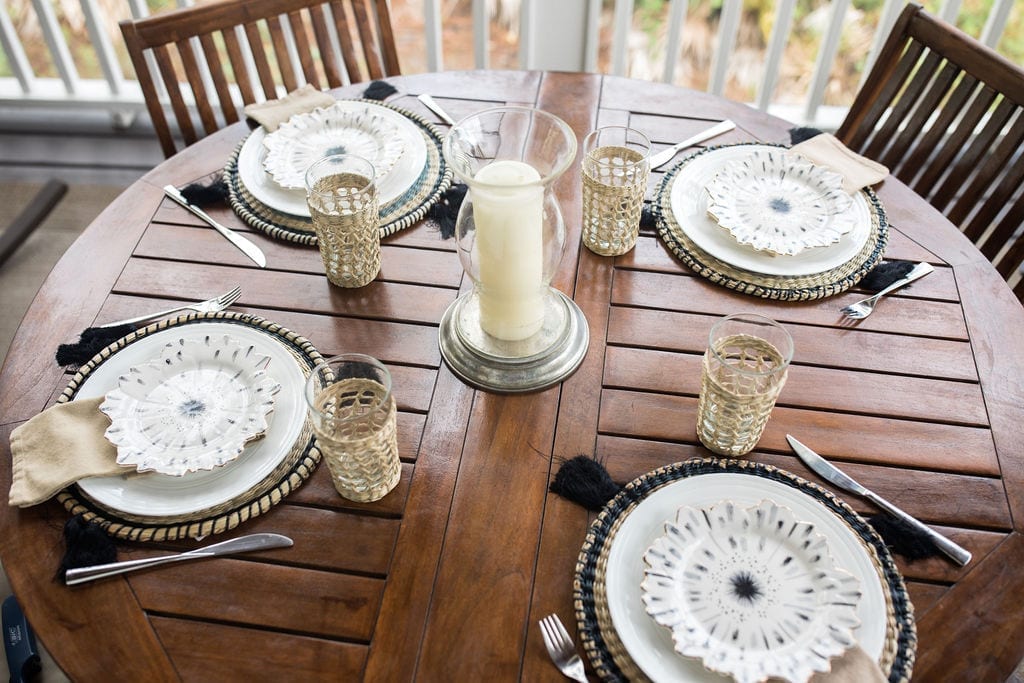 Gold and black table settings are both coastal and glamorous all t once with hints of gold leaf, wicker rattan round placemats and wicker cups. Add glamorous Anthropologie plates for an elegant table.