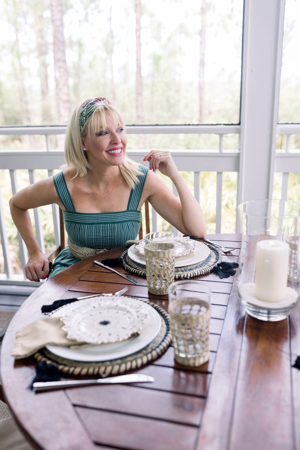 Table settings with round placemats for outdoor coastal glam table setting with accents of wicker, black and gold.