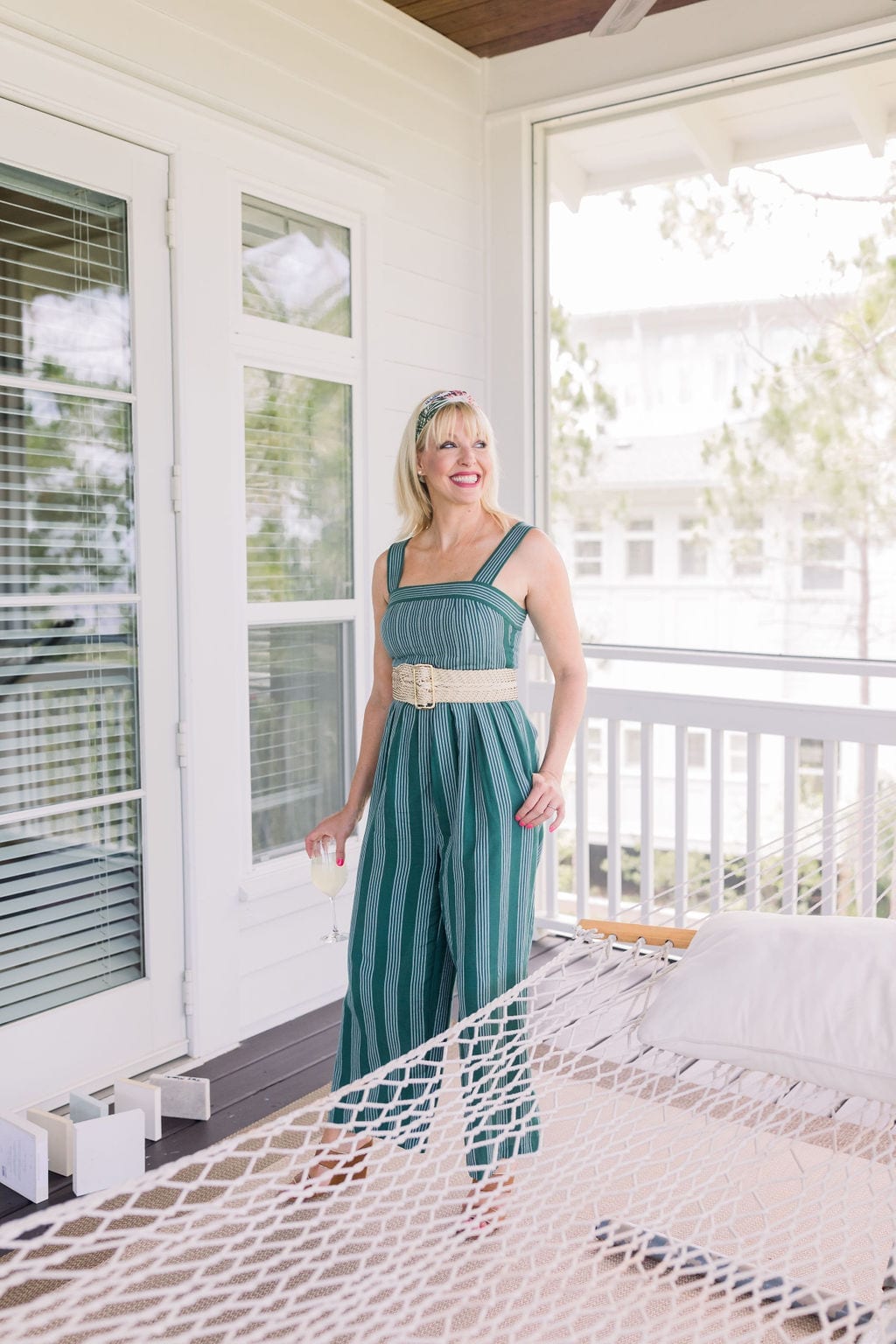 Anthropologie jumpsuit in emerald green with wicker belt and floral headscarf. Great summer jumpsuit for women with short torso's and long legs.