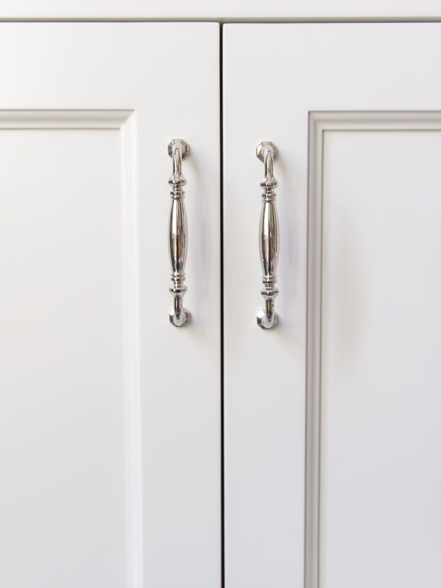 Polished Nickel Hardware on white bathroom cabinets.