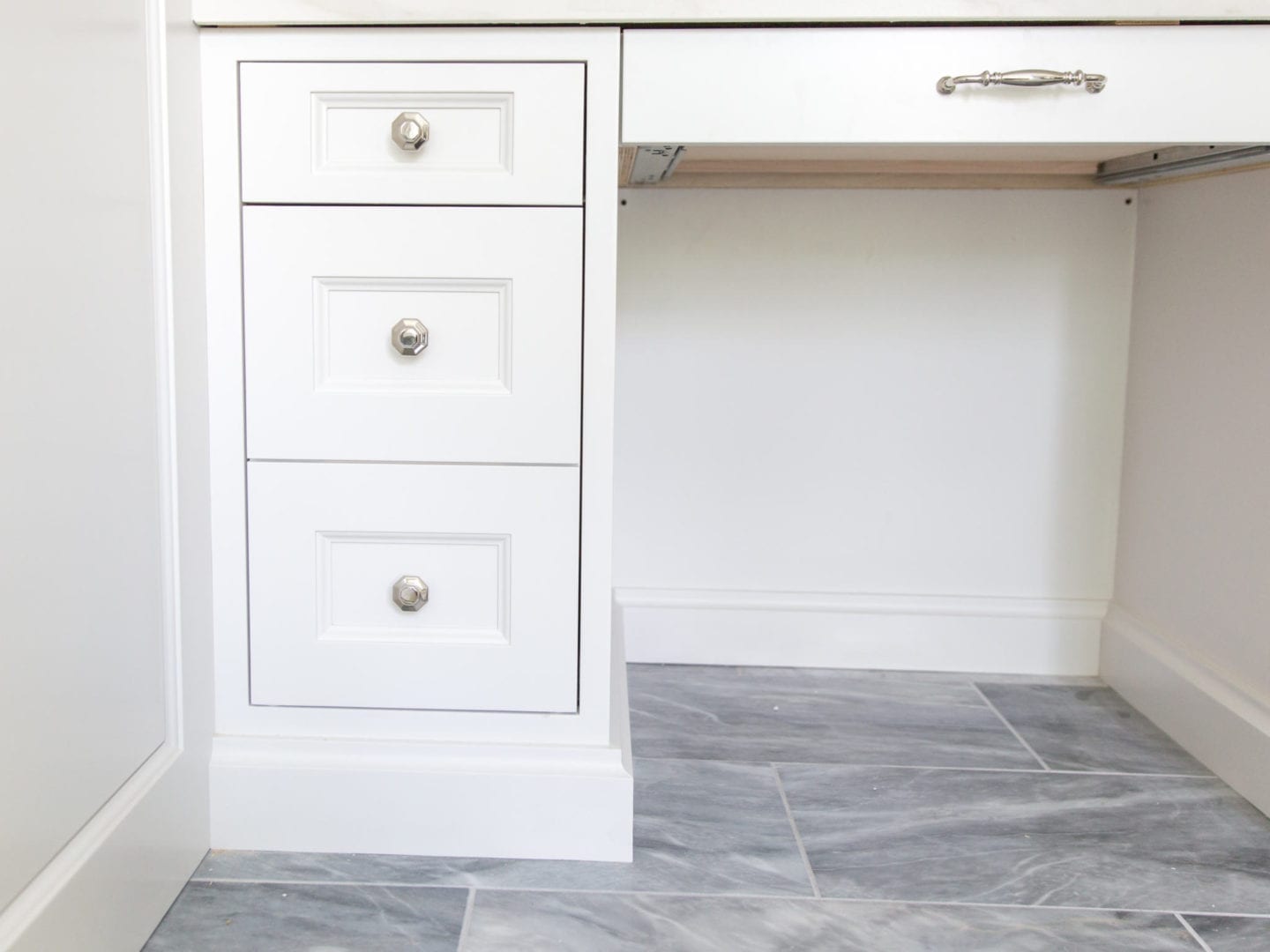 Bathroom cabinets with VESTA polished nickel hardware. Elegant hardware with gray marble floor.
