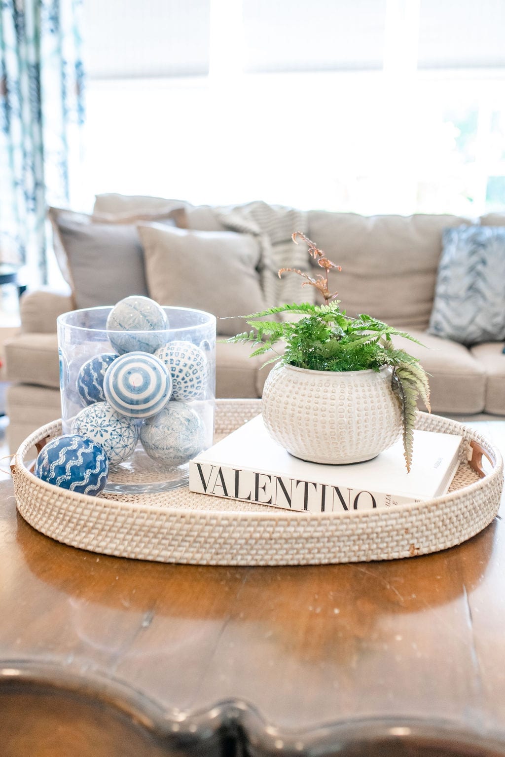 How to decorate your coffee table in neutral and blue colors. Coffee Table Decor Ideas with blue glass balls and blue drapes.