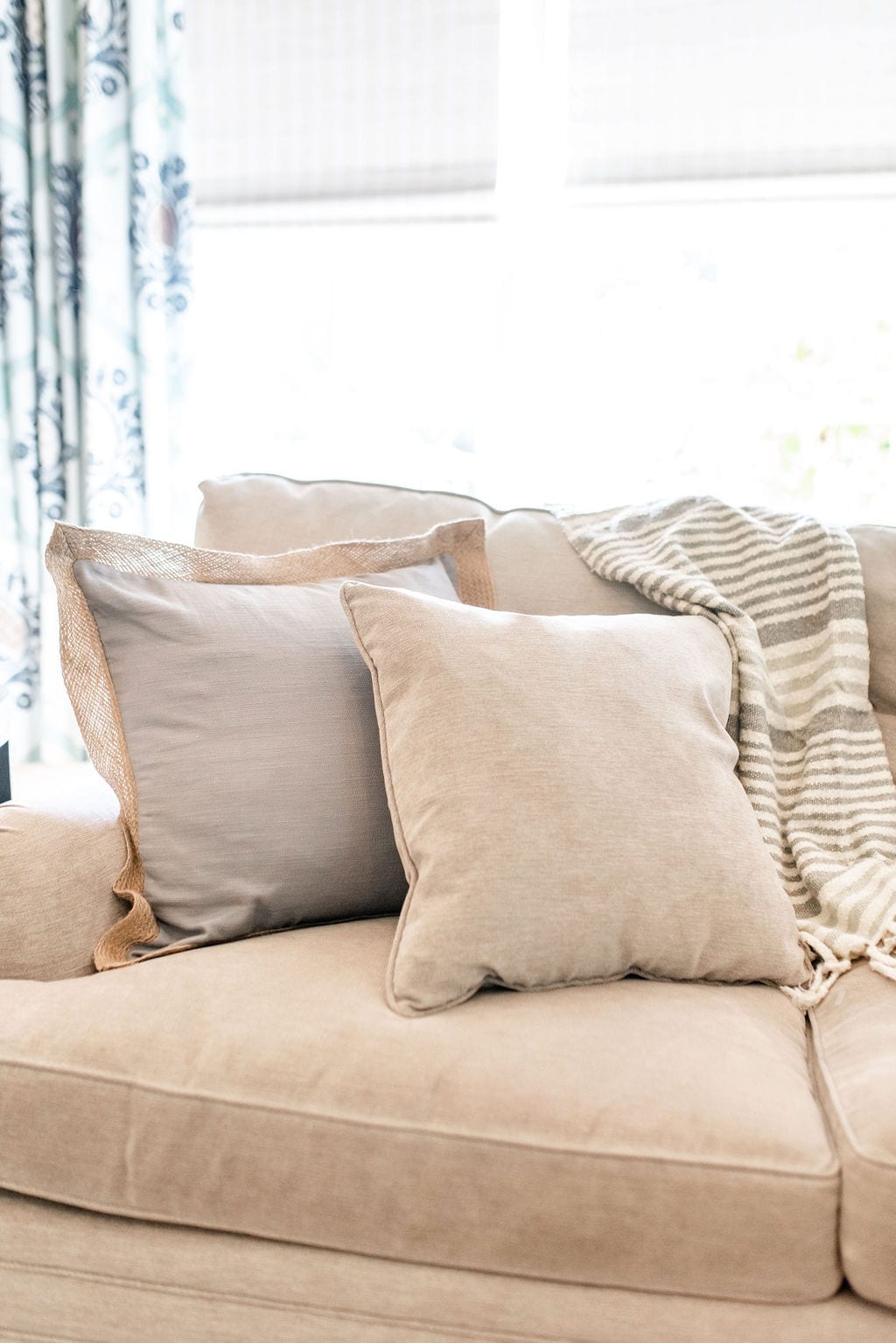 Chenille Taupe Couch with burlap throw pillow. Theordore Alexander couch with taupe stripe throw blanket from Wayfair.