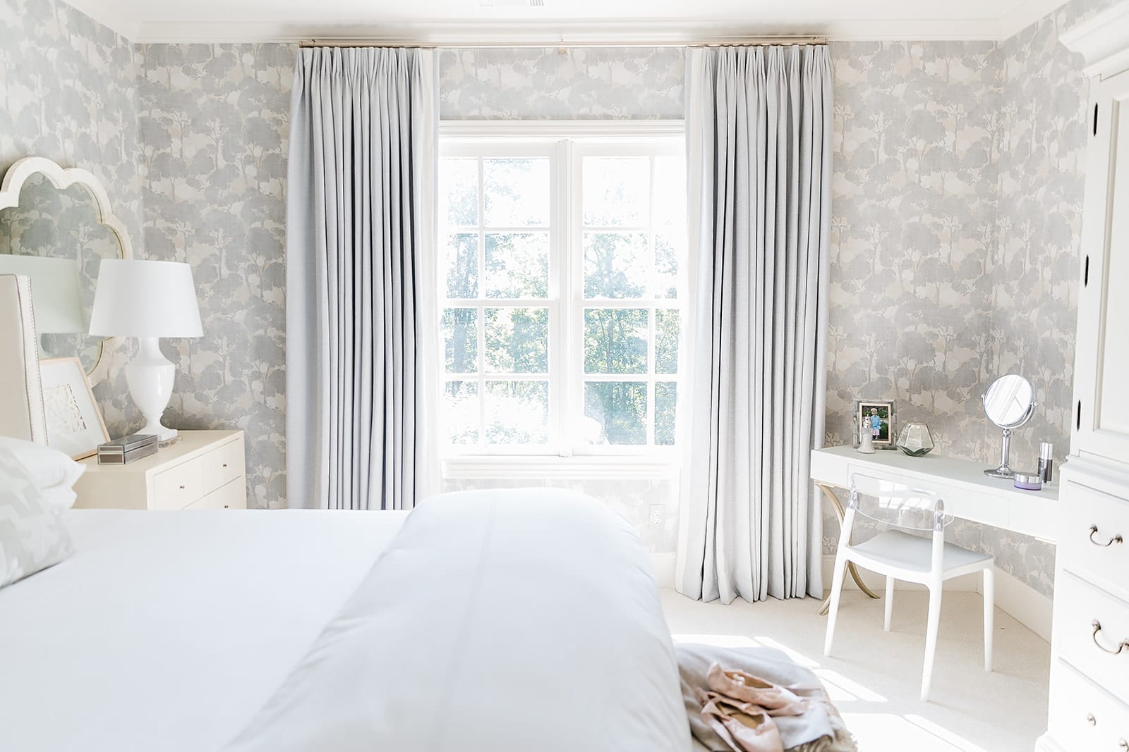 Lavender Bedroom decor. Homegoods vanity in faux shagreen, white table lamps, quatrafoil wall mirror and custom Drapery and wallpaper from Calico Corners.