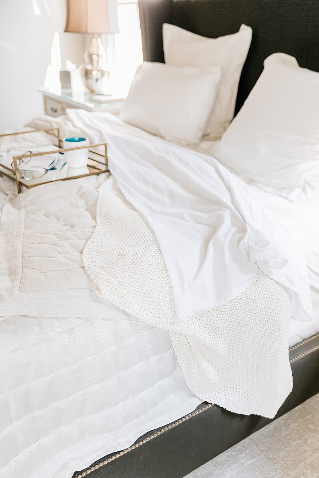 Ivory Hotel Sheets for fall. Dark bedroom with light ivory sheets and ivory knit blanket.