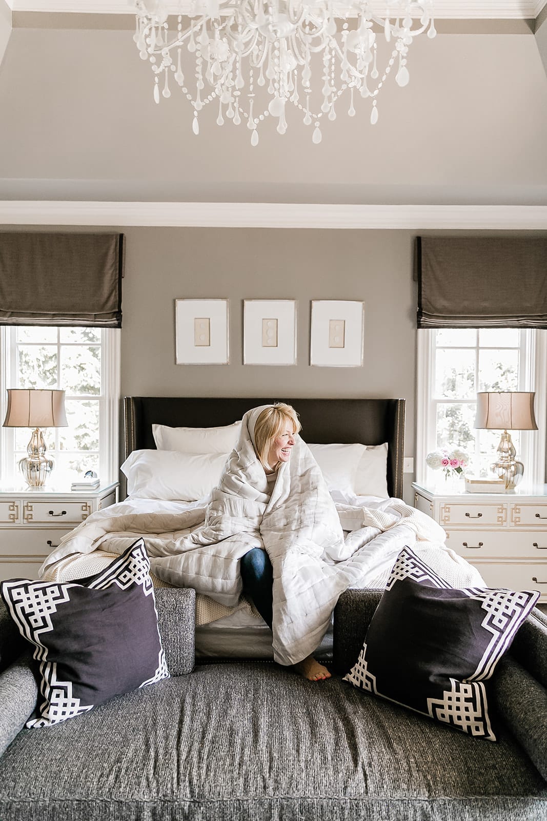 Atlanta blogger Kelly Page, BlueGrayGal, in master bedroom decorated with white chandelier, intaglio prints, gray Benjamin Moore paint, blue bench and ivory Annie Selke bedding.