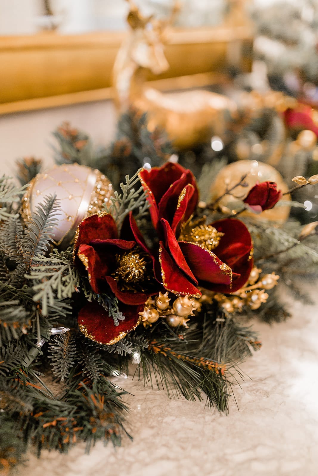 Red and gold magnolia garland. Gold tree picks and light gray ornaments mixed with gold glitter.