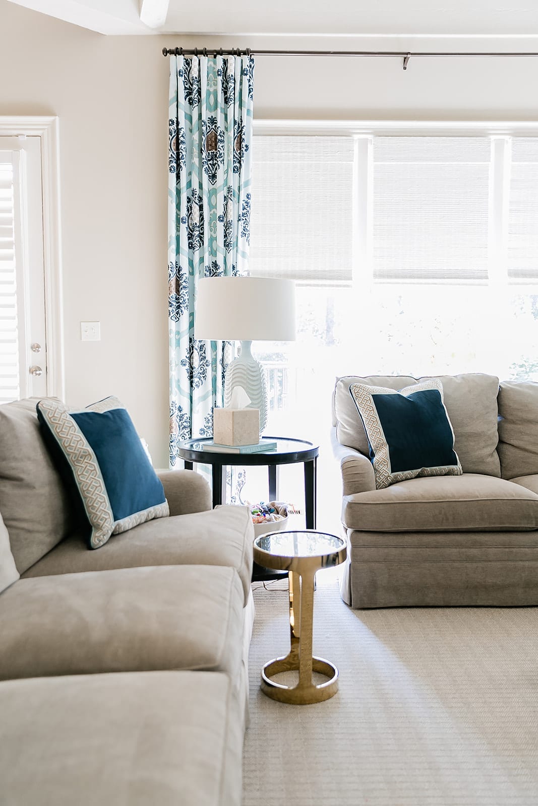 Navy Velvet Throw Pillow in blue and beige family room decor with neutral couch and blue drapery.