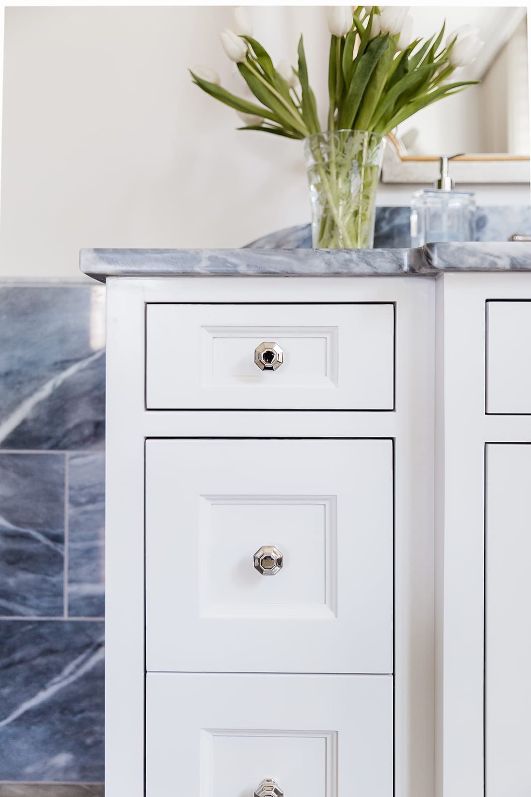 VESTA hardware. Polished nickel hardware on bathroom vanities. Bardiglio gray marble and white bathroom cabinets.