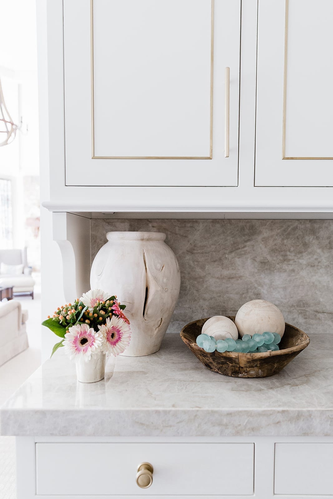 Wood Home Decor accents with gold cabinet pulls and gold and white kitchen cabinet built ins.