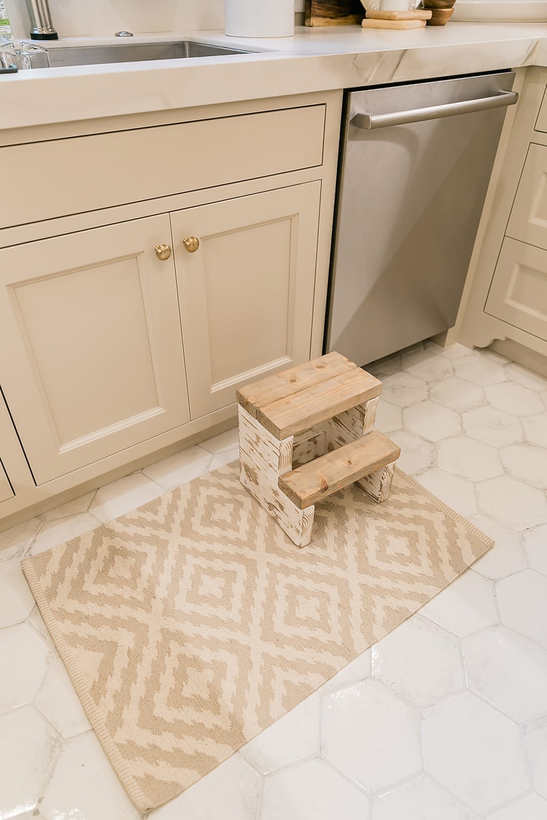 Kitchen Cabinets in Accessible Beige with Dash & Albert rug and Etsy Farmhouse stool. Bosch stainless steel dishwasher.