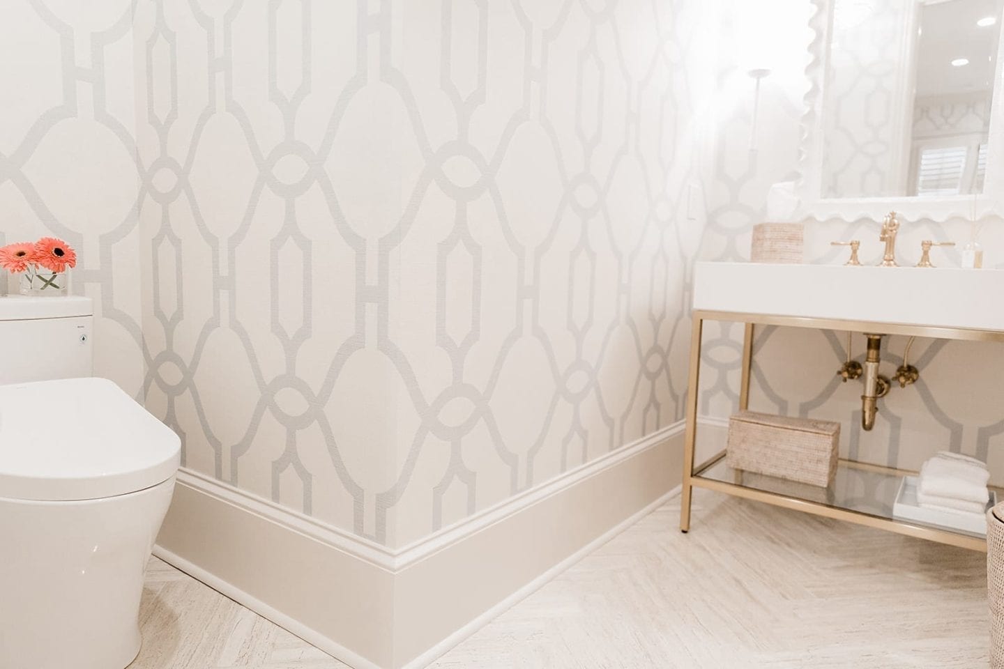 TOTO bidet toilets with Joanna Gaines wallpaper, herringbone travertine floor and white mirror.