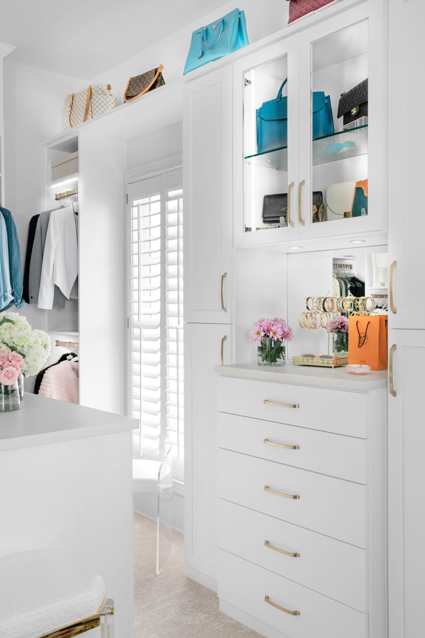 Luxury closet with closet purse display along the top with led lights to illuminate them for a store like closet.