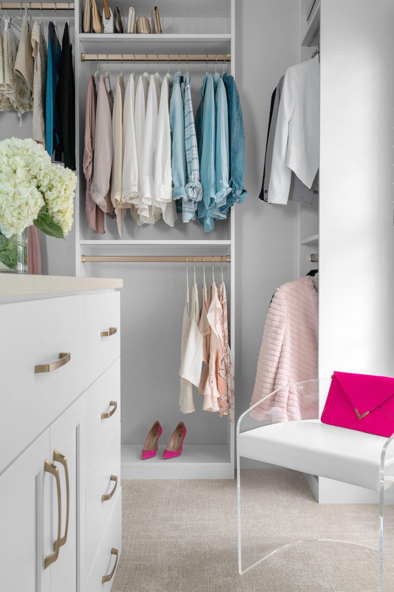 Acrylic chair and closet with white linen and gold hardware.